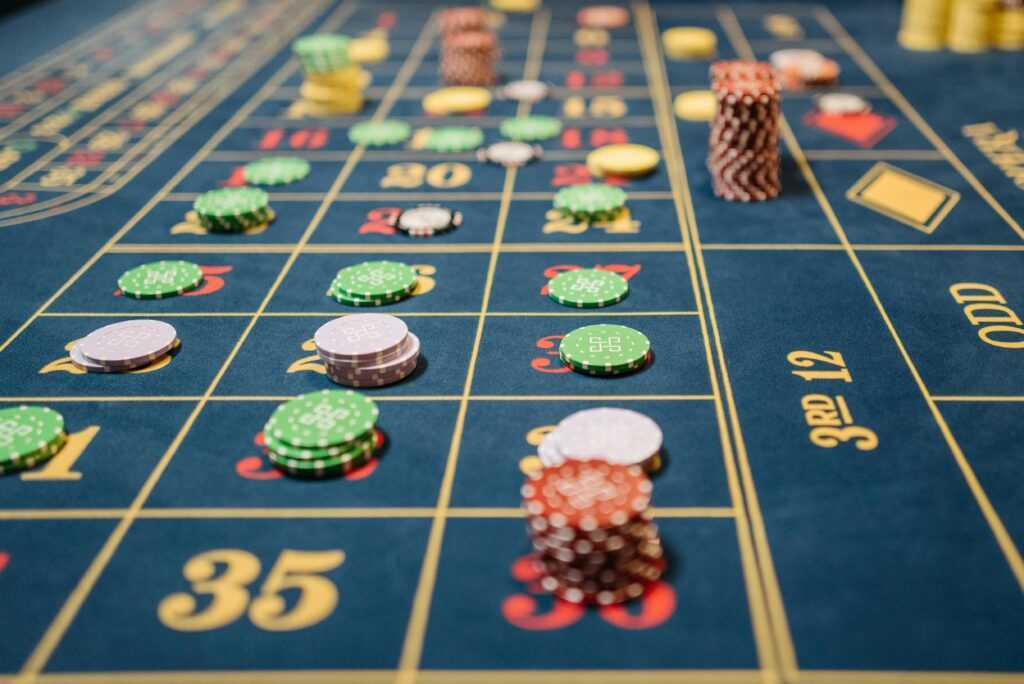 Close-up of a roulette table with colorful poker chips, capturing the thrill of casino gambling.