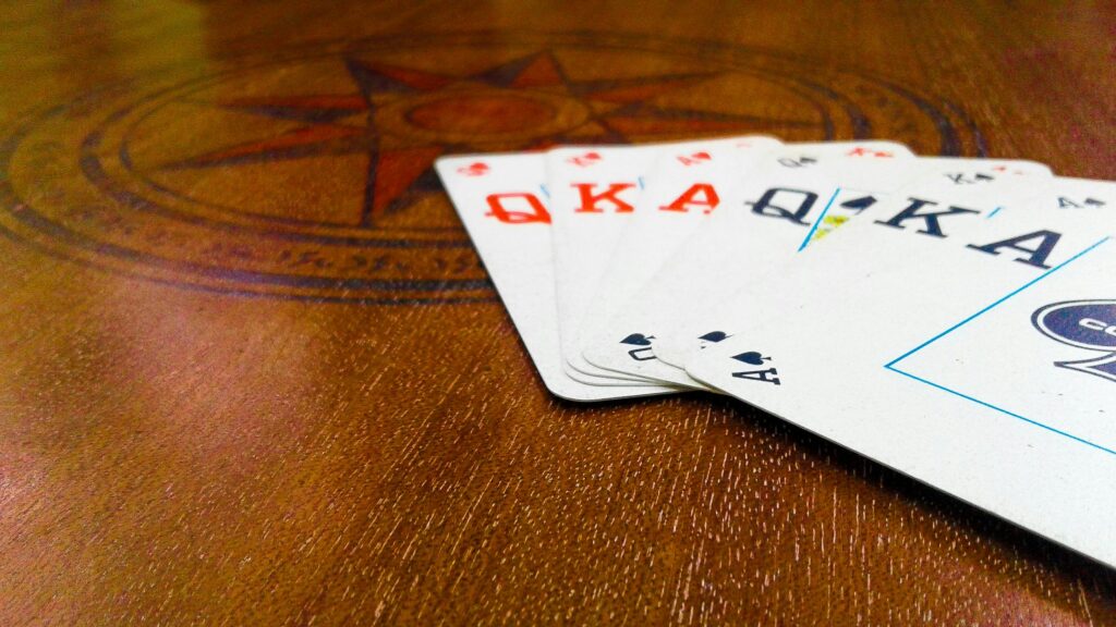 Playing cards fanned out on a decorative wooden table, highlighting strategic leisure.
